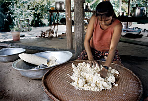 mulher preparando a farinha de mandioca